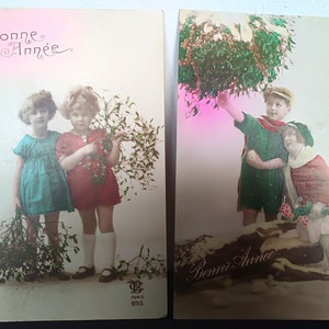 Conjunto de 1925 de dois cartões coloridos de Ano Novo franceses antigos, cartões postais românticos, crianças com roupas da Belle Époque com flores