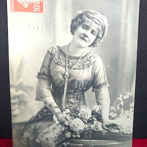 Postal francesa en sepia, tarjeta de Año Nuevo "Bonne Fete", Chica con hermoso collar de perlas y ramo con un vestido bellamente bordado. ramo de rosas