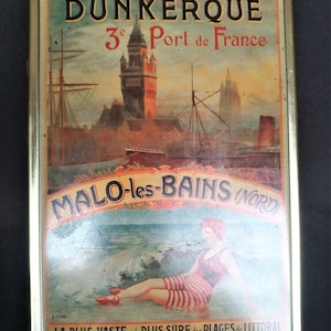 Puede incluir: Caja de hojalata vintage con una ilustración colorida de una ciudad costera, una mujer en traje de baño y el texto "Dunkerque 3e Port de France Malo-les-Bains (Nord) La Plus Vaste et la Plus Sure des Plages du Littoral".