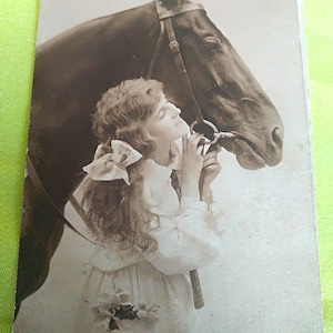 Señorita con un precioso vestido largo blanco y un lazo en el pelo posando con su caballo. Mapa belga de chocolates Le Cerf Verviers. 20