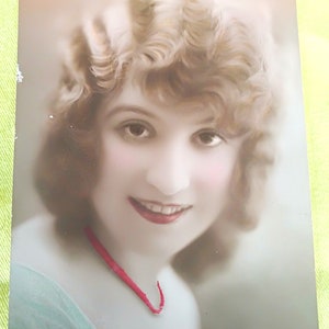Carte postale française représentant une charmante jeune femme avec une coiffure et un maquillage des années 1920, un collier rouge. Collections, collages, scrapbooking