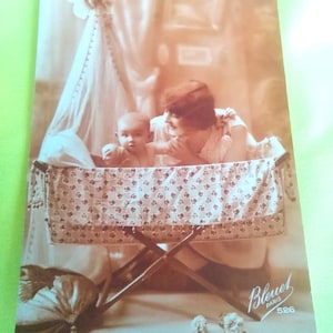 Cartolina francese color seppia raffigurante una mamma con un simpatico bimbo in culla degli anni 20. Carta della marca Bleuet Paris.