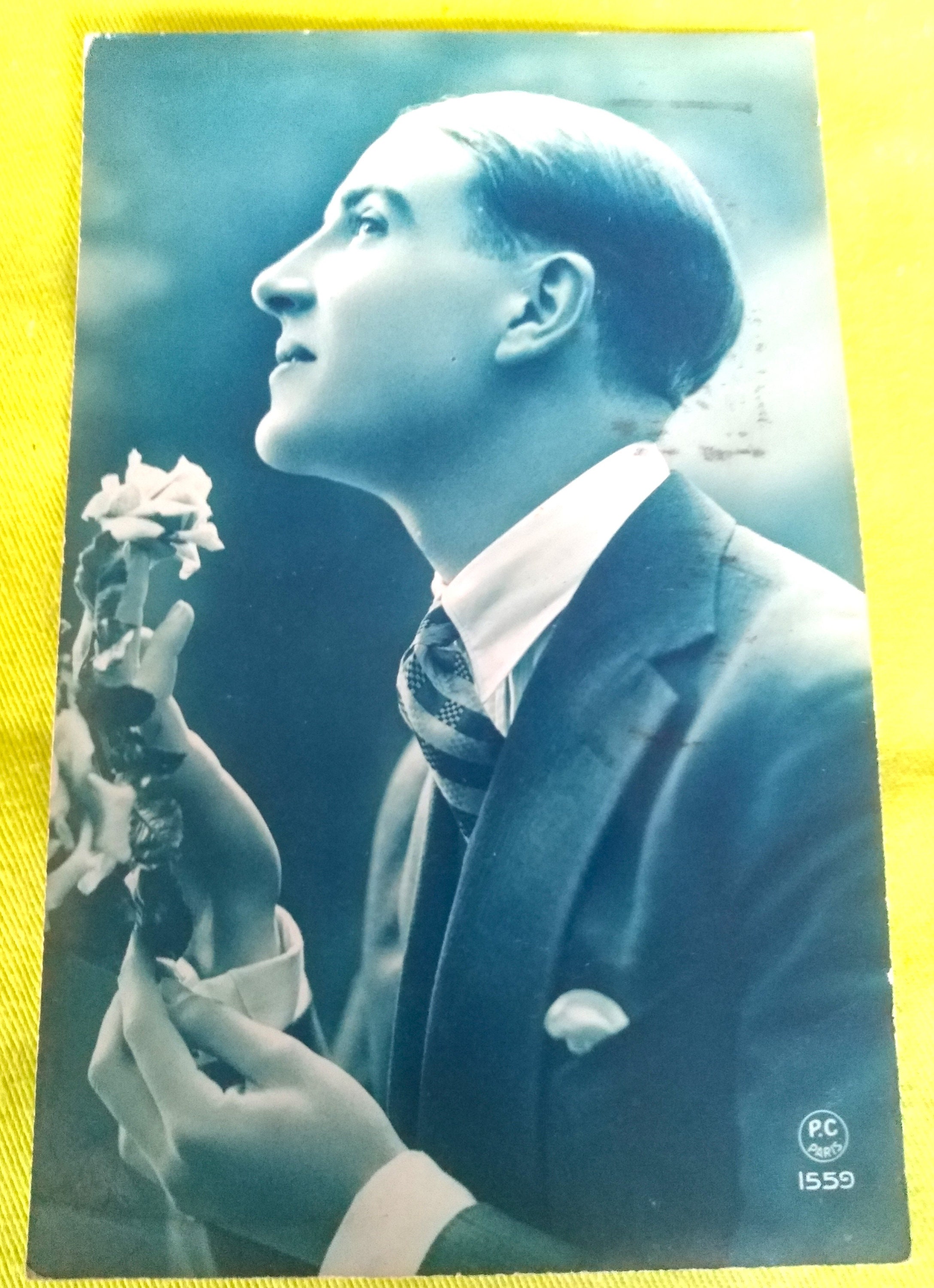 French postcard from the Firma P.C. Paris. French Young Man Eagerly Looking Forward to His Love, Beautiful 1920s Suit and Flower