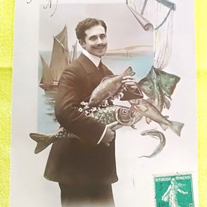 Carta da pesca di aprile del 1912, Uomo con guadino e pesce d'aprile tra le braccia. Bellissimo outfit Belle Epoque e scena marittima sullo sfondo.
