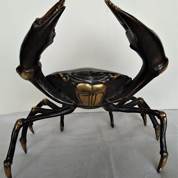 Bild einer Krabbenfigur aus braun und glänzend patinierter Bronze. Tischdekoration, Meeresfrüchte-Buffet, Bankett mit Meeresfrüchten, Strandhaus, Maritimes Dekor