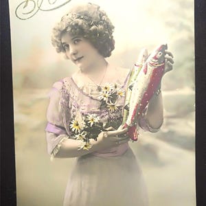 Hermosa postal para el 1 de abril, Elegante dama con dos peces de abril y un hermoso ramo de flores. Te traen felicidad.  1 de abril de 1912