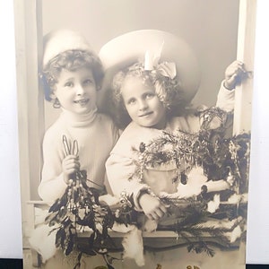 Cartão de Ano Novo Francês, com data de 1912, Duas crianças com lindas flores rodeadas por uma moldura de janela. Lindos chapéus. Bonne Annee