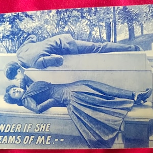 Postal americana, postal de 1913, Dama en el sofá con caballero, "Me pregunto si ella sueña conmigo - - Tarjeta azul y blanca con fondo de bosque