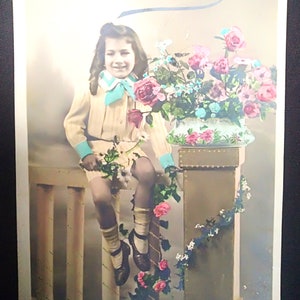 Carta francese mai usata degli anni '10 raffigurante una ragazza con un bellissimo taglio di capelli lunghi e abiti alla moda dell'epoca. La bellezza dei fiori in un vaso