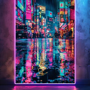 Puede incluir: Una impresión de un paisaje urbano iluminado con neón que presenta una escena de calle lluviosa con luces vibrantes rosas, azules y amarillas que se reflejan en el pavimento mojado. La imagen está enmarcada con un borde rosa brillante.