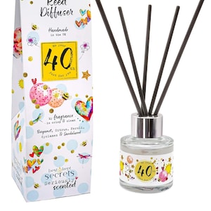 Könnte beinhalten: Eine weiße Geschenkbox mit bunten Illustrationen und dem Text "Just Because... Reed Diffuser Handmade in the UK On Your 40th Just for You" und eine klare Glasflasche mit silbernem Deckel und schwarzen Schilfrohren. Die Flasche hat ein buntes Etikett mit dem Text "On Your 40th Just for You" und einem Bienen- und Blumendesign.