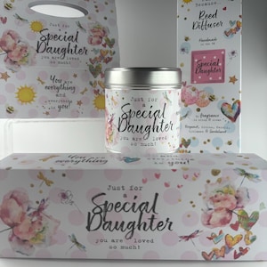 May include: A gift set with a floral theme, featuring a candle tin, a gift bag, and a reed diffuser box. The items are decorated with watercolor flowers, dragonflies, hearts, and the text "Just for a Special Daughter".