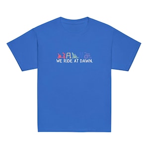 May include: A royal blue t-shirt with a line of colorful lawnmower silhouettes and the text "WE RIDE AT DAWN."