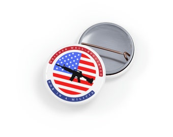 May include: A white button with a red, white, and blue American flag design. The flag has a black silhouette of a rifle on top of it. The text around the flag reads "Neither Well Regulated Nor In A Militia".
