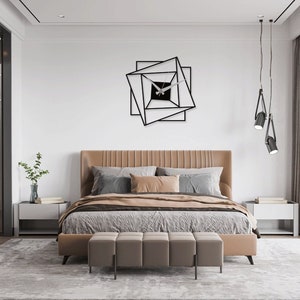 May include: A modern bedroom with a brown leather bed, a geometric black wall clock, and two black pendant lights hanging from the ceiling.