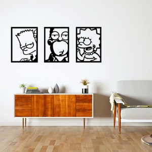 Può includere: Tre opere d'arte da parete con cornice nera raffiguranti personaggi dei cartoni animati. L'opera raffigura Bart, Homer e Lisa Simpson in uno stile minimalista. L'arte è esposta sopra un mobile in legno con piano bianco e un divano grigio.