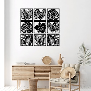 May include: A set of nine black metal wall decor pieces featuring tropical leaf and flower silhouettes. The pieces are arranged in a grid pattern and are mounted on a white wall.