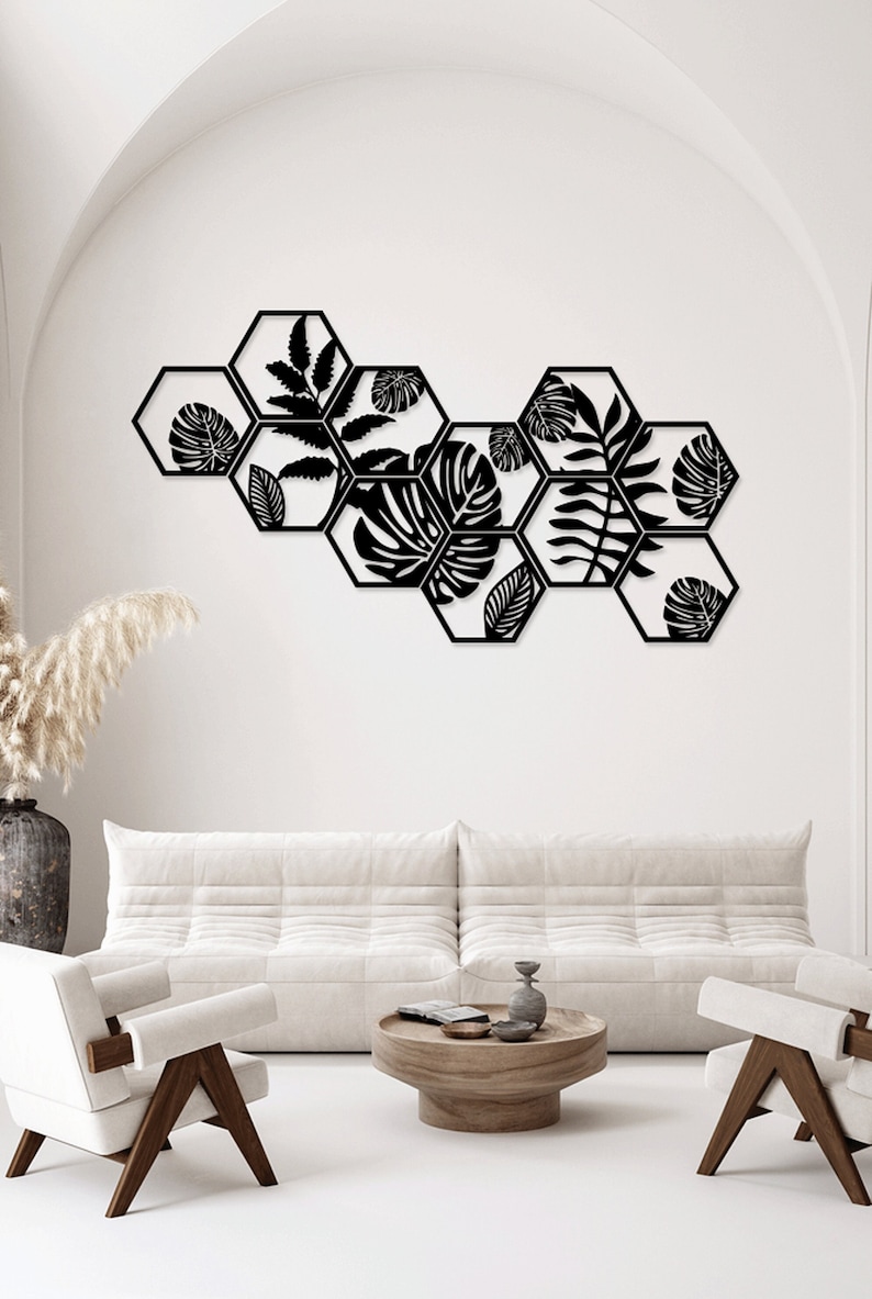 May include: A wall decor set featuring eight black metal hexagonal shapes with cut-out leaf designs. The shapes are arranged in a staggered pattern, creating a modern and stylish look.