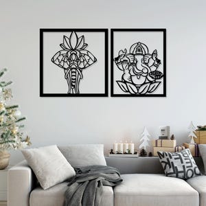 May include: Two black metal wall art pieces with intricate designs. The left piece features an elephant with a lotus flower behind it. The right piece features a deity with multiple arms holding various objects.