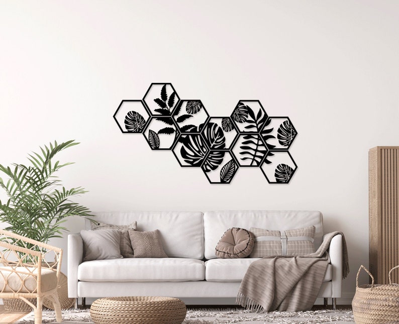 May include: Black metal wall decor featuring a geometric design of hexagonal shapes with cut-out tropical leaf patterns.
