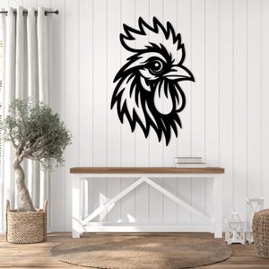 May include: Black metal rooster head wall decor. The rooster is facing right and has a detailed design. The rooster is mounted on a white wall.