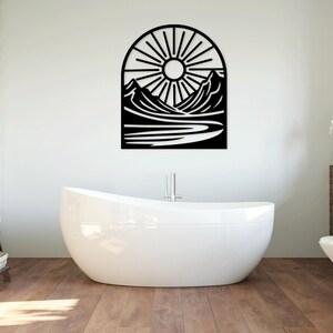 May include: Black metal wall art depicting a sun setting behind mountains and a river. The art is in the shape of an arch.