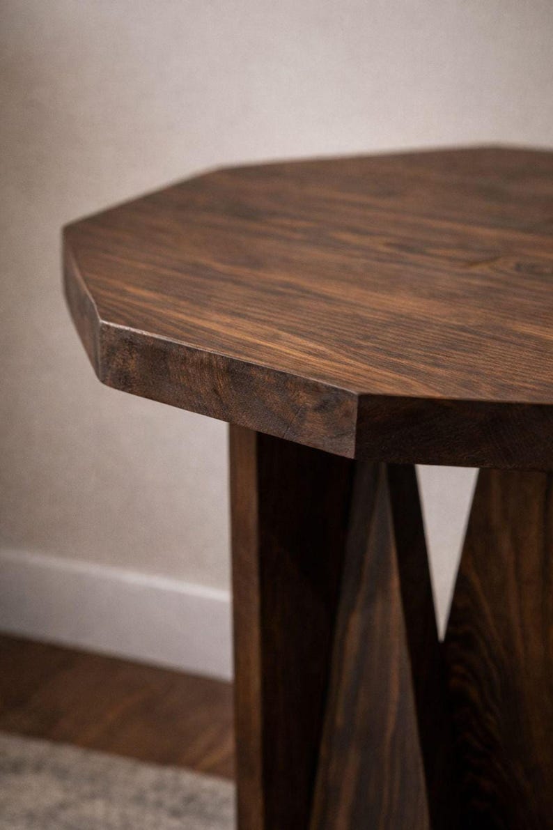Close-up of octagonal top and beveled edge, dark walnut grain visible on handmade wood end table pedestal.