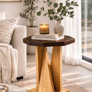 Golden oak small wooden side table in bright living room, used as wood plant stand with candle and leafy plant.
