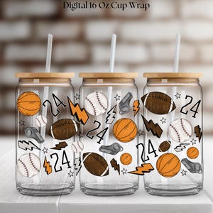 Peut inclure: Trois verres transparents avec des couvercles en bois et des pailles. Chaque verre présente des illustrations sur le thème du sport, notamment des ballons de basket, de baseball, de football américain et des éclairs. Le chiffre "24" est également affiché sur chaque verre.