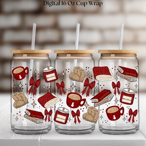 May include: Three clear glass cups with bamboo lids and straws. Each cup is decorated with red and beige illustrations of books, bows, mugs, candles, and boots. The text "Digital 16 Oz Cup Wrap" is at the top.