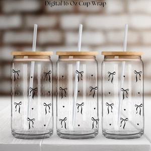 May include: Three clear glass cups with bamboo lids and white straws. Each cup is decorated with a pattern of black bows and hearts. The text "Digital 16 Oz Cup Wrap" is at the top.