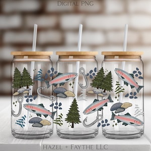 May include: Three clear glass drinking cups with bamboo lids and white straws. Each cup features a design of a trout, fishing hook, pine trees, and rocks. The words "DIGITAL PNG" and "HAZEL + FAYTHE LLC" are visible.