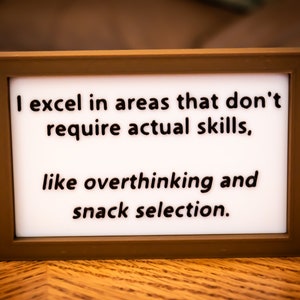 Funny Desk Sign - "I excel in areas that don't require actual skills, like overthinking and snack selection."