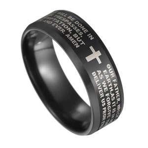 Peut inclure: Bague noire avec une croix argentée et la prière du Seigneur gravée autour de la bande.
