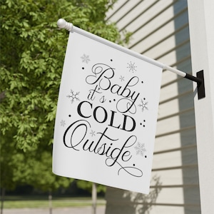 May include: White winter flag with black text that reads "Baby it's COLD Outside" with snowflakes scattered around the text.