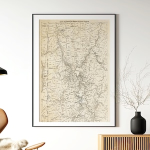 May include: A framed vintage-style map of the Greater Pittsburgh area in black ink on a beige background. The map features intricate street layouts, a large circular boundary line, and the text "Live In and Expand Your Business In Greater Pittsburgh" printed clearly at the top centre of the document.