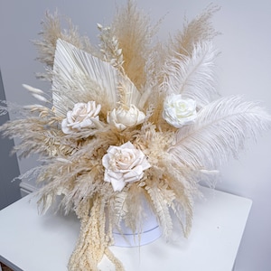 May include: A white ceramic mug with a black handle and the text "But First, Coffee" in a black, handwritten-style font. The mug is on a white surface.