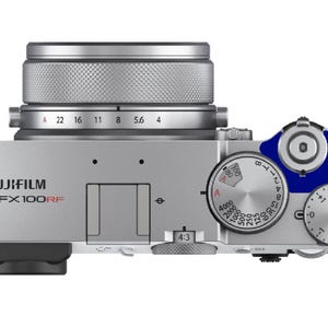 Puede incluir: Vista superior de una cámara Fujifilm GFX100RF plateada con una lente y diales. La cámara tiene un cuerpo plateado con detalles en negro y azul. La lente tiene ajustes de apertura. Se puede leer el texto "FUJIFILM GFX100RF".