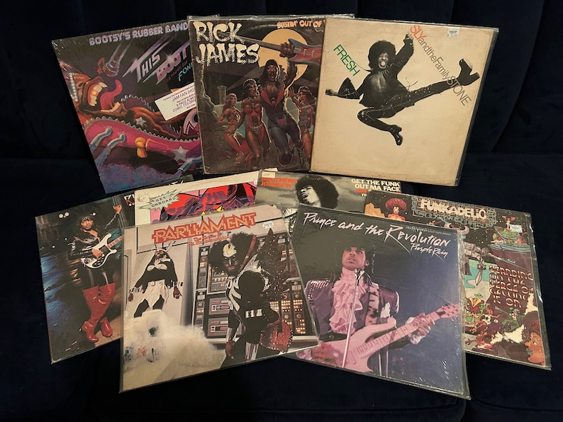 May include: A collection of ten vintage vinyl records by various artists, including Rick James, Parliament, Funkadelic, Prince, and Sly and the Family Stone. The records are in various colors and feature different album covers.
