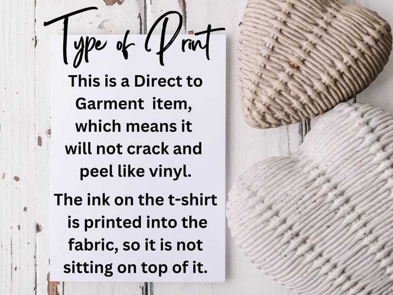May include: White card with black text explaining the type of print used on t-shirts. The text reads "Type of Print. This is a Direct to Garment item, which means it will not crack and peel like vinyl. The ink on the t-shirt is printed into the fabric, so it is not sitting on top of it."