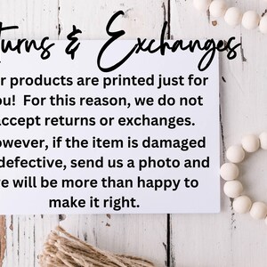 May include: White card with black text on a white wood background. The text reads "Returns & Exchanges" and explains the shop's return policy. The shop does not accept returns or exchanges, but will replace damaged or defective items.
