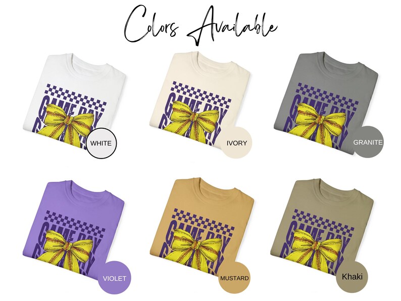 May include: A collection of t-shirts in various colors, each featuring a purple and white "Game Day Ready" graphic with a yellow bow. The colors available are white, ivory, granite, violet, mustard, and khaki.