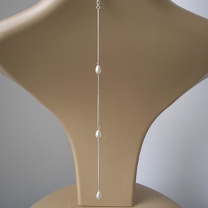 Simple dainty teardrop pearl clip-on backdrop attachment for a necklace.
Handmade to order using 7mm quality glass teardrop pearls on fine silver or gold plated curb chain.
The backdrop will be made to your chosen length and is finished with a little lobster clasp, for easy attachment to your necklace.