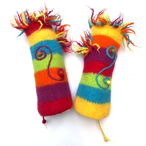 Peut inclure: Deux marionnettes à doigts en tricot coloré avec des rayures arc-en-ciel, jaune, orange, rouge, rose, violet, bleu et vert. Chaque marionnette a une petite boule de feutre colorée et une ficelle en feutre orange bouclée attachée.