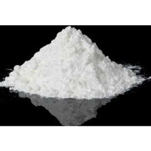 May include: A large pile of white powder on a black surface. The powder is finely ground and has a smooth texture.