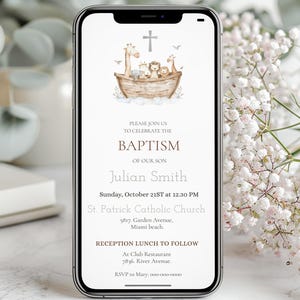 May include: A smartphone displays a baptism invitation. The design features an illustration of animals on an ark, a cross, and text that reads "BAPTISM of our son Julian Smith" with event details. The invitation is set against a soft, neutral background.