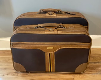 May include: Two brown and tan suitcases with a Regency label on the front. The suitcases have a striped design on the front.