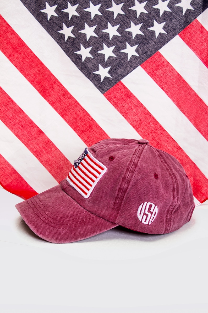 May include: A burgundy baseball cap with a small American flag patch and a white embroidered "USA" on the back.
