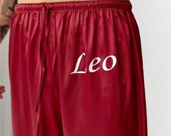 May include: Red satin pajama pants with a white drawstring and the name "Leo" embroidered on the front.