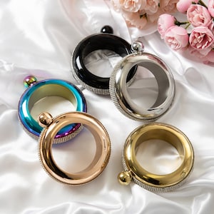 May include: Five different colored metal bracelets with rhinestones. The bracelets are in a variety of colors, including gold, silver, black, and iridescent.